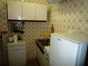 A compact kitchen with a refrigerator, a sink, and a small countertop. - One-bedroom Apartment in Nerja (Nerja)