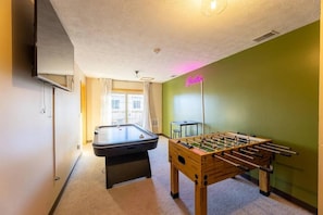 A room with a pool table, a foosball table, and a neon sign. - The Burrow at Silver Creek | Ski Access, Hot Tub (Snowshoe)