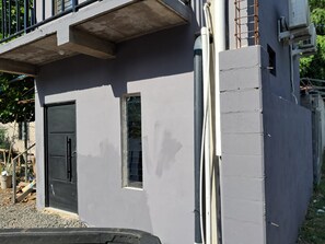 A building with a grey exterior, a black door, and a window.