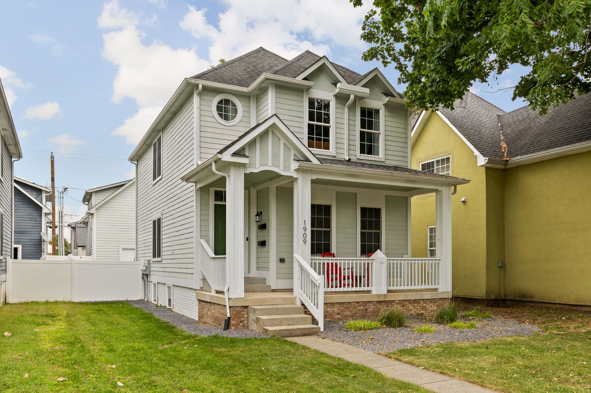 A two-story house with a front porch and a small front yard.