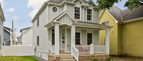 A two-story house with a front porch and a small front yard.