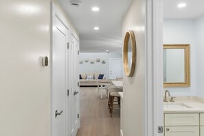 Um interior moderno com área de cozinha, mesa de jantar e sala de estar com sofá e poltronas.