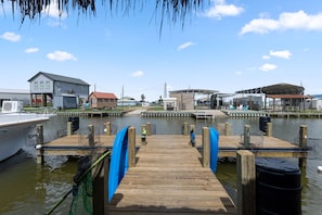 A wooden dock leading to a marina with boats, a house, and a covered area. - The Lady Luck In Water Docked Studio Boat Room (Bay City)