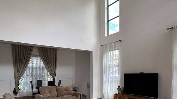 Un amplio salón con una gran televisión de pantalla plana, sofás cómodos y una mesa de centro de madera.