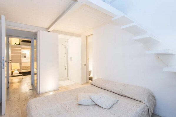 A bedroom with a bed, a walk-in closet, and a staircase. - Fori Imperiali Hi Tech Apartment (Roma)