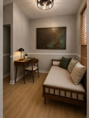 A room with a wooden bed, a desk with a chair, a lamp, and a large abstract painting on the wall. - Spacious 3-bedroom condo in Lake View, Chicago (Chicago)