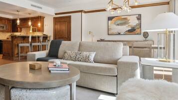 Un salon moderne avec un canapé, une table basse ronde et un pouf blanc à poils longs.