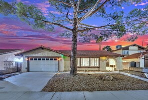 A residential area with houses, a driveway, and a tree. - Vegas Angel • Pool, Arcade Room & Strip Views (Las Vegas)