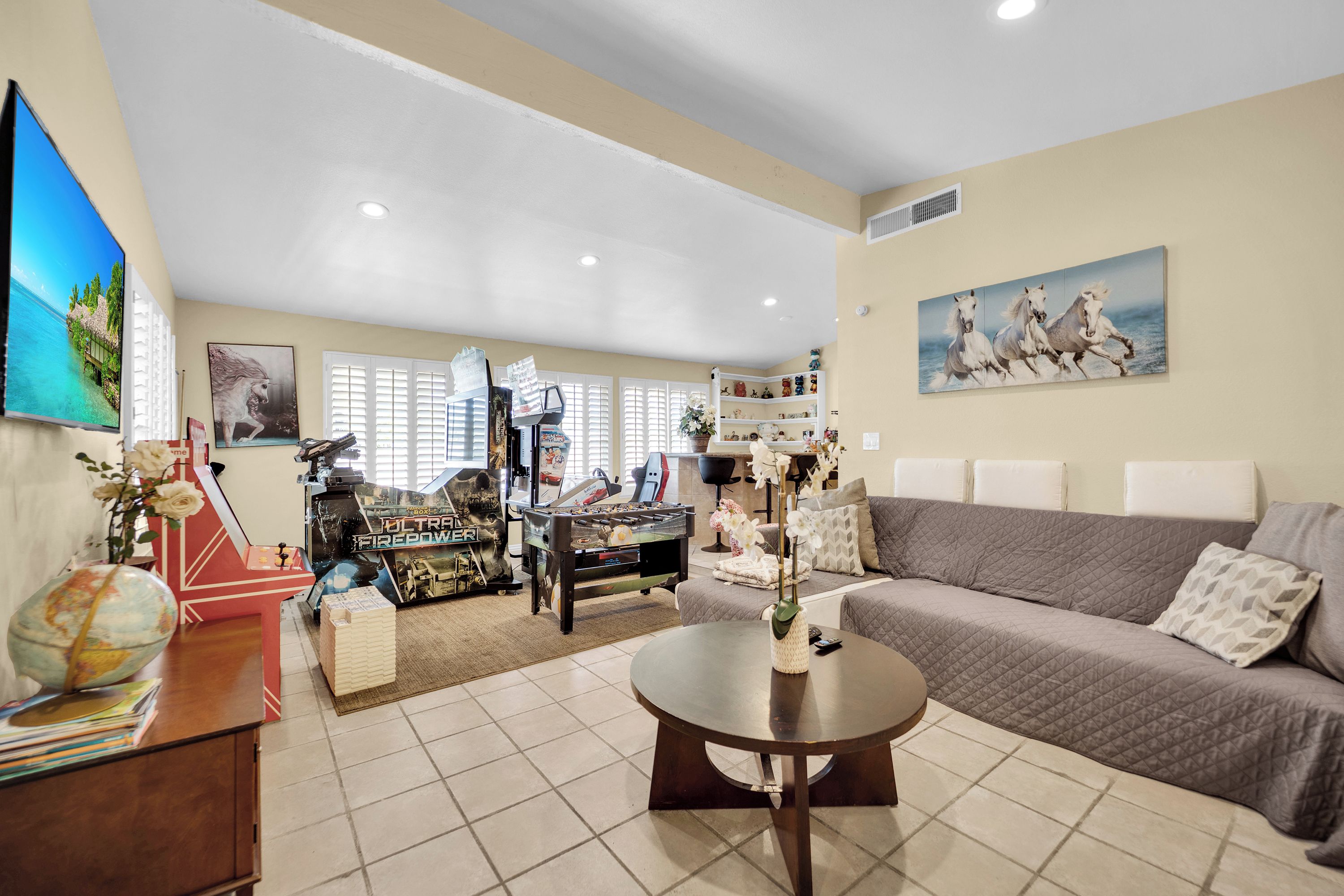 A living room with a sofa, a coffee table, and a foosball table.