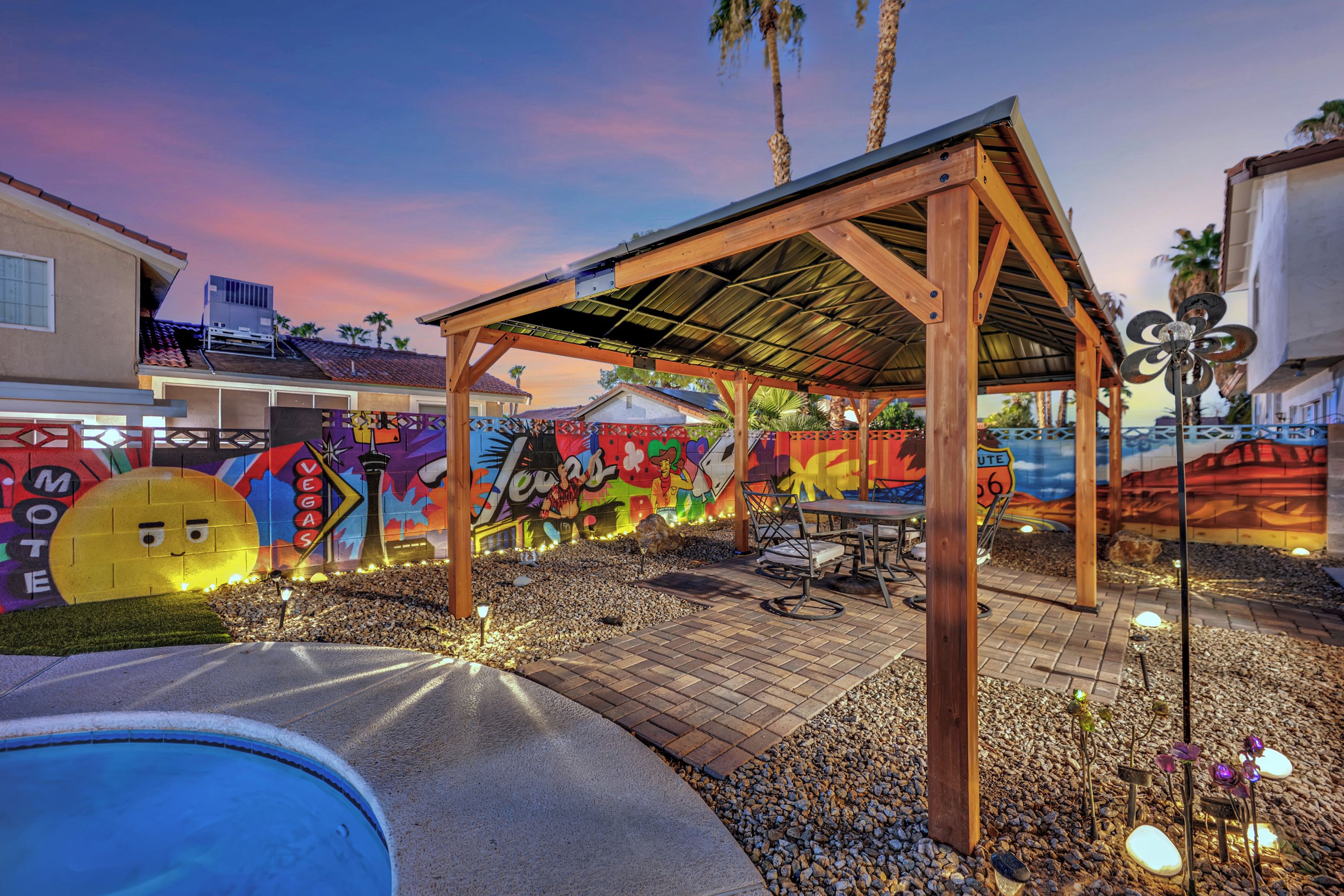 A covered outdoor seating area with a pool, surrounded by colorful graffiti walls.