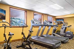 Ein Fitnessstudio mit Ergometer, Laufbändern und Rudergerät.