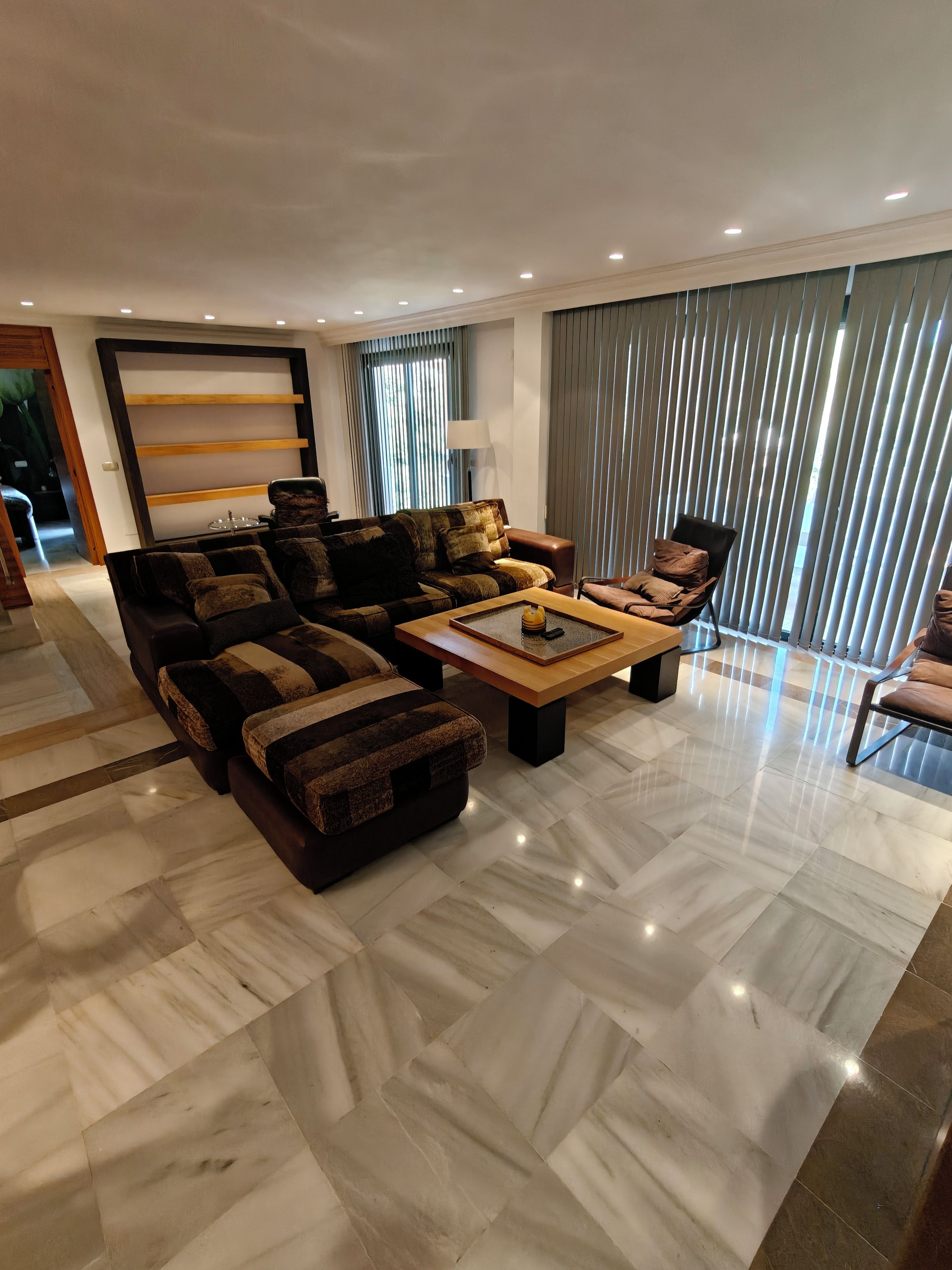 A modern living room with a sectional sofa, a coffee table, and a chair.