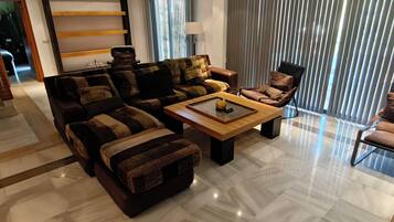 A modern living room with a sectional sofa, a coffee table, and a chair.