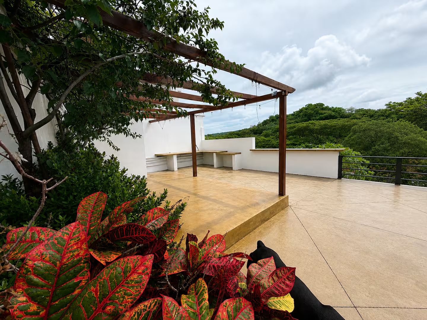 Terraza en la azotea con pérgola, zona de estar y vistas a zonas verdes.