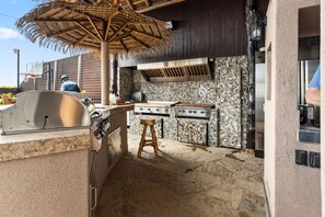 An outdoor kitchen with a grill, a stove, and a dining area with a table and chairs. - The Treasure Hunter In Water Docked Studio Boat (Bay City)