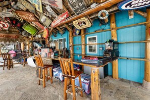 A tiki bar with wooden furniture, a bar counter, and various signs including Budweiser and Corona Premier. - The Treasure Hunter In Water Docked Studio Boat (Bay City)