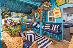 A room with a nautical theme, featuring striped furniture, a fish decoration, and a sign that reads 'The Crab Shack.' - The Treasure Hunter In Water Docked Studio Boat (Bay City)