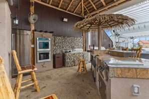 A kitchen with a stone backsplash, a built-in oven, a refrigerator, and a wooden bar counter. - The Treasure Hunter In Water Docked Studio Boat (Bay City)