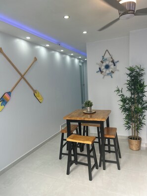 A room with a wooden table and chairs, a ceiling fan, recessed lighting, a wall-mounted ship's wheel decoration, and a potted plant. - Caribe House, just 7 minutes from the San Juan airport, close to everything (Carolina)