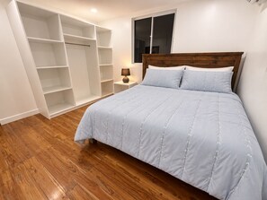 A bedroom with a bed, a wardrobe, and a nightstand. - Horizonte Apartment: Nature and Pool (Sucio (San Juan del Sur))