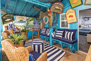 A room with a nautical theme, featuring striped furniture, a fish decoration, and a sign that reads 'The Crab Shack.' - The Black Pearl Dry Docked Studio Boat Room (Bay City)