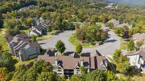 A residential area with houses, a winding road, and surrounding greenery. - Okemo Ski Escape | Steps to the Slopes (Ludlow)