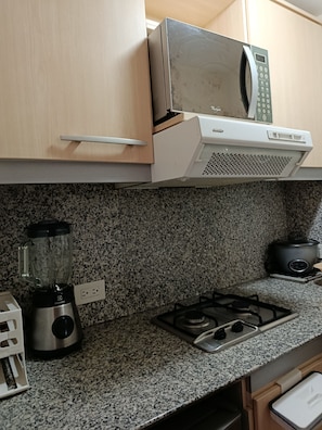 A kitchen with a microwave, stove, blender, and a slow cooker. - LUXURY SUITE, Comfortable and Fully Furnished (Quito)
