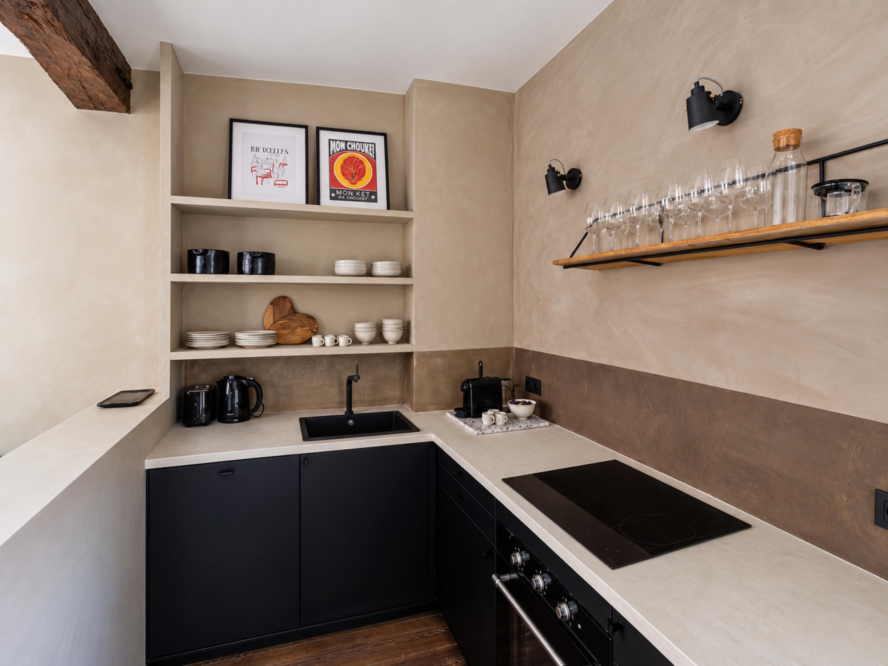 Een moderne keuken met zwarte kastjes, een wit aanrechtblad en een ingebouwde oven.