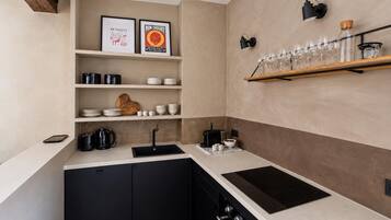 Een moderne keuken met zwarte kastjes, een wit aanrechtblad en een ingebouwde oven.