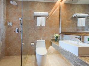 Ein Badezimmer mit Duschkabine, Toilette, Waschbecken und Spiegel.