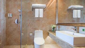 Un bagno moderno con doccia vetrata, un water bianco e un ampio lavandino con specchio sopra.