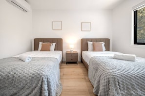 Ein Hotelzimmer mit zwei Betten, einem Nachttisch und einem Fenster.