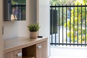 A modern bathroom with a wooden vanity, a potted plant, and a large mirror. - Brand-New|Walk to Cavill & Beach| Glink |Full A/C (Surfers Paradise)