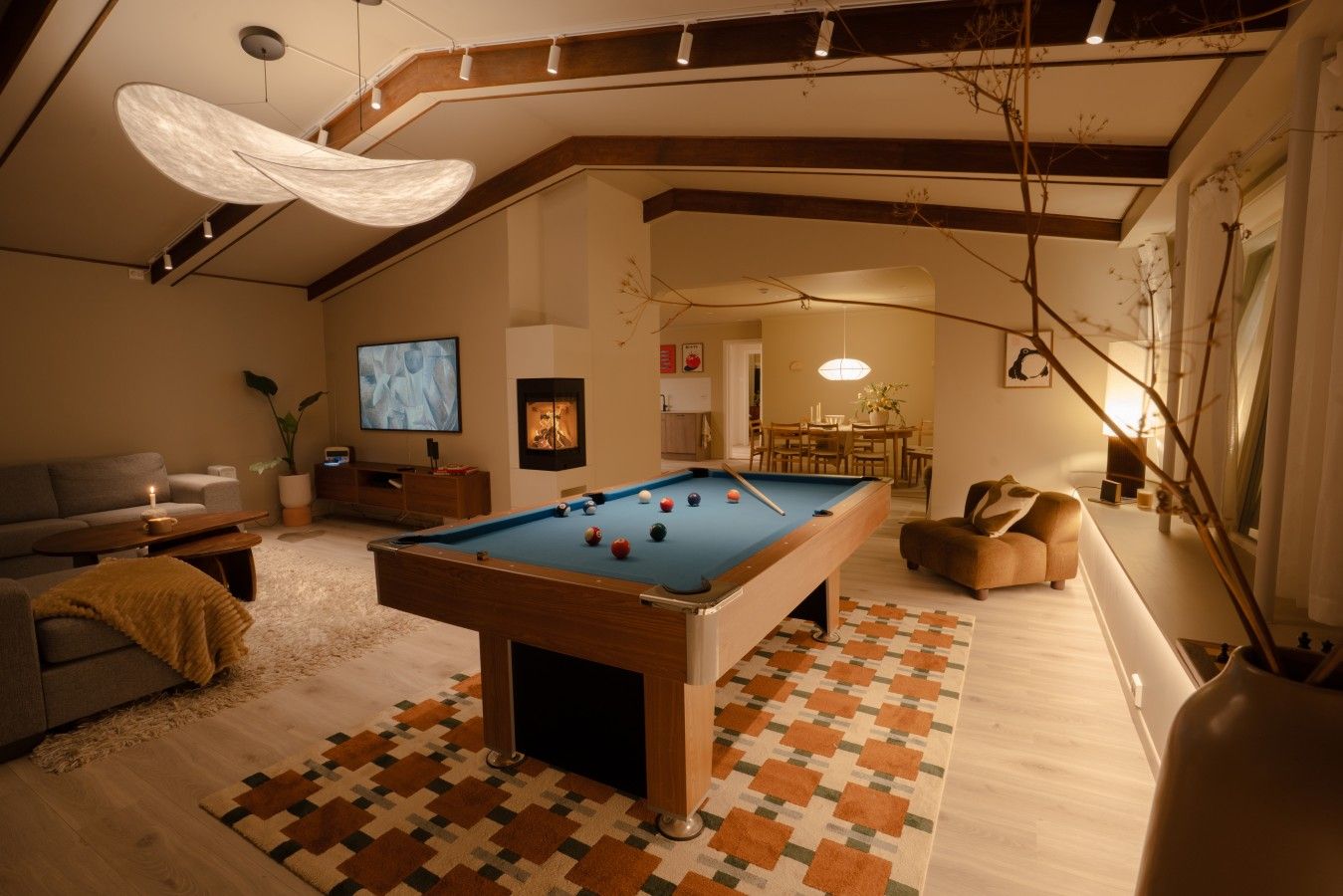 A cozy indoor space with a pool table, seating area, and a television.