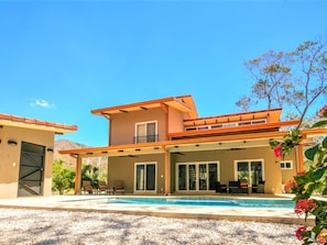 A modern two-story house with a covered patio area and a swimming pool. - Tropical Villa • Private Pool • Near Conchal & Flamingo (Brasilito)