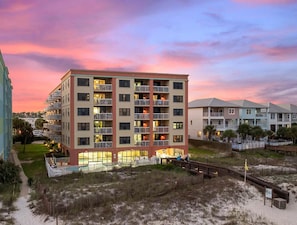 Een hotel met meerdere verdiepingen, балконы, een zwembad en uitzicht op het strand.
