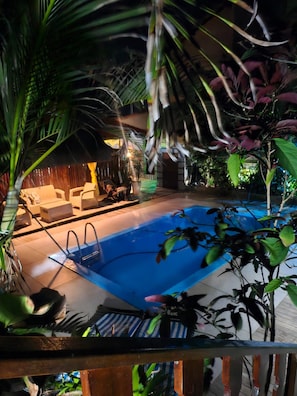 An outdoor swimming pool with lounge chairs and a wooden deck.