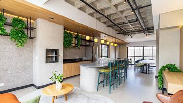 Een moderne keuken met een centraal eiland, barkrukken en een zithoek met een ronde tafel.