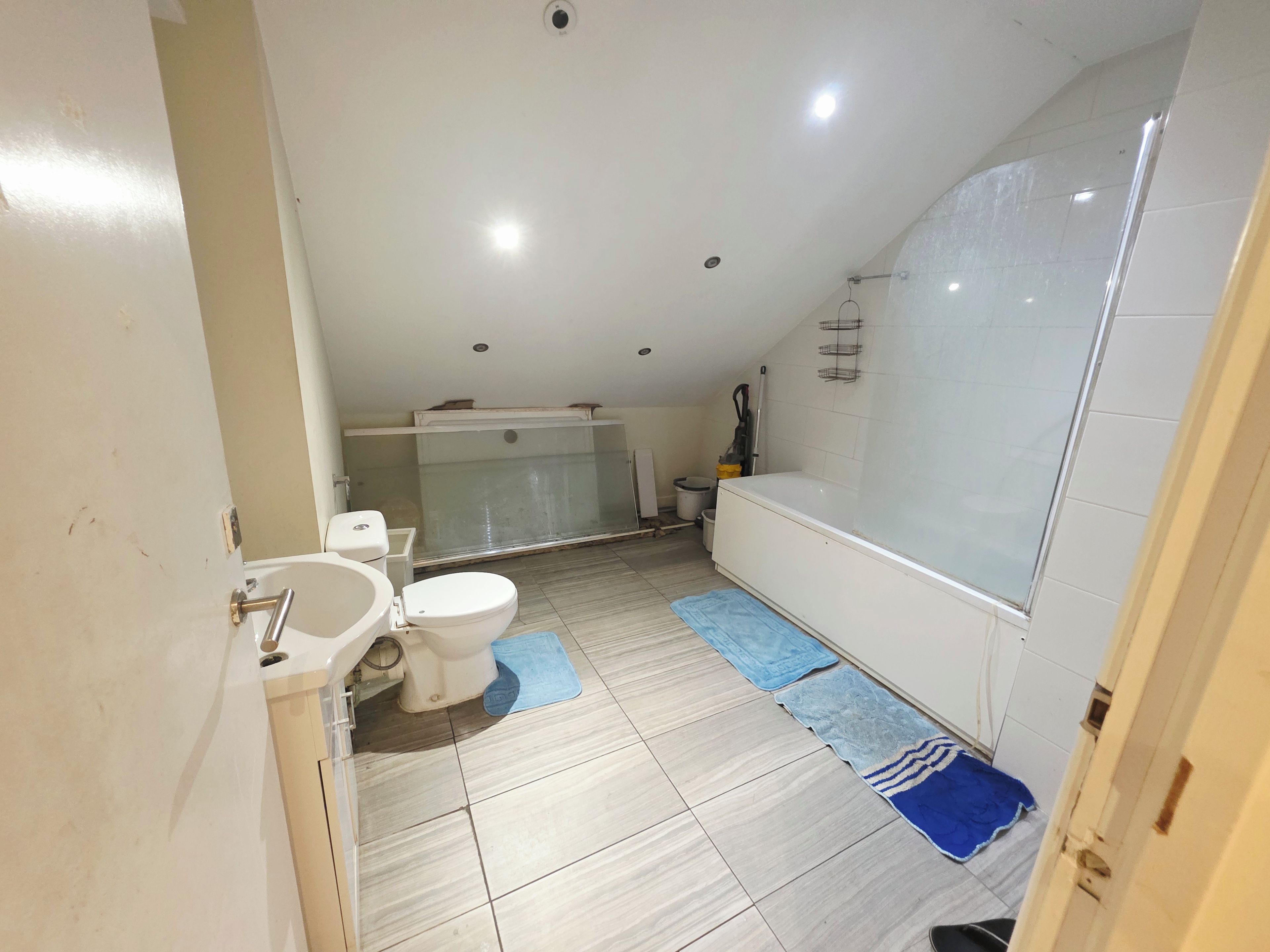 A bathroom with a toilet, bidet, bathtub, and a shower area.