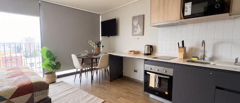 A modern kitchen with a built-in oven, microwave, and a dining area with a table and chairs.