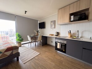Une cuisine moderne équipée d’un four encastré, d’un four à micro-ondes et d’un coin repas avec une table et des chaises.