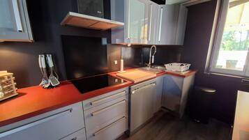 A modern kitchen with a built-in dishwasher, a stainless steel sink, and a window providing natural light.