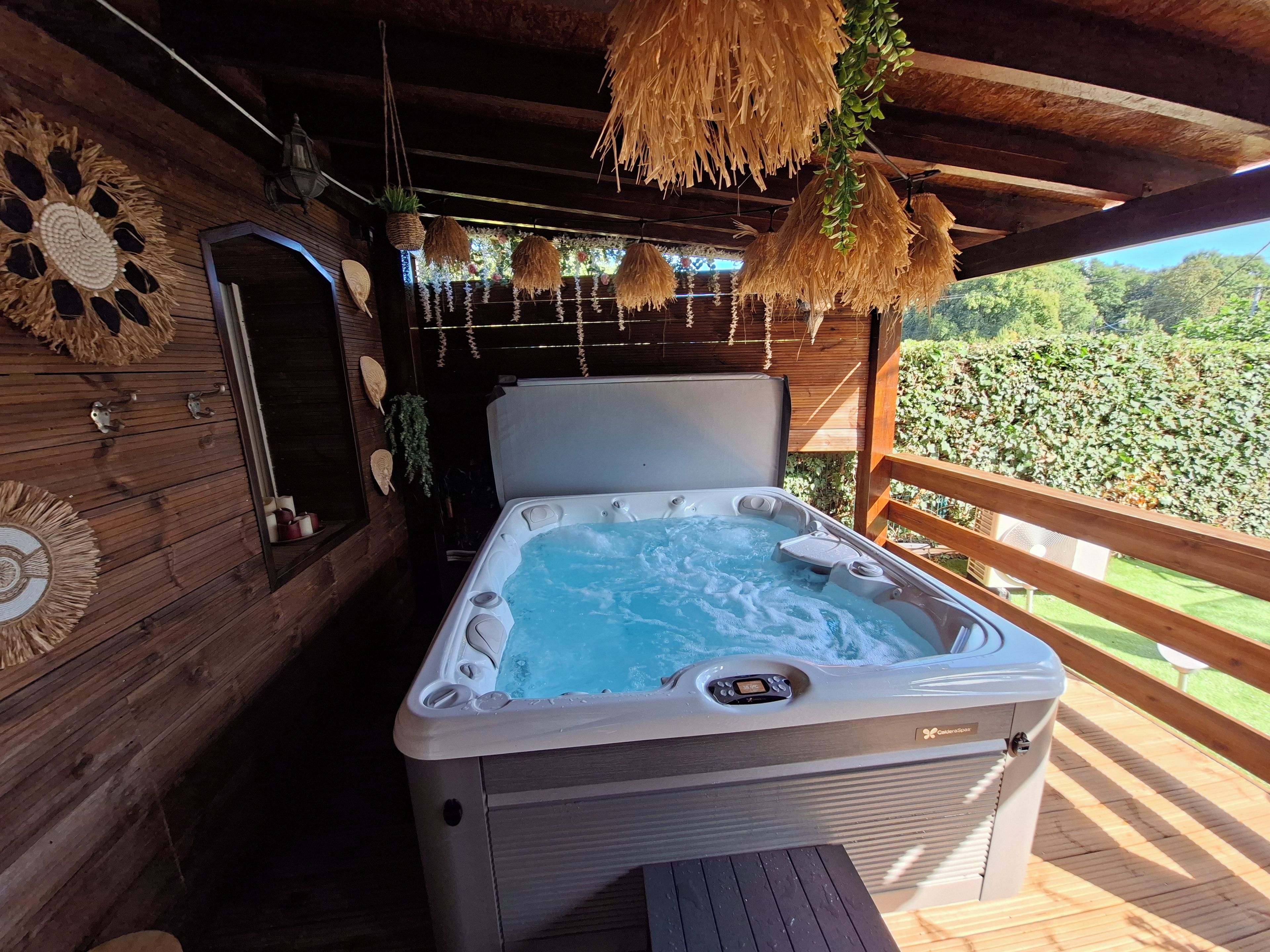 Un jacuzzi en una terraza de madera con vista a la vegetación.