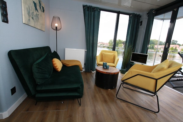 Una sala moderna con un sofá verde, un sillón amarillo y una mesa de centro redonda.