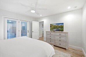 A bedroom with a bed, a dresser, a television, and a ceiling fan. - Walk to Ski Trolley | Private Hot Tub | Sleeps 23 (Park City)