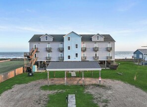 A multi-story residential building with a covered patio area, located near a beach. - Casa Dora Cove Beachfront (Bolivar Peninsula)