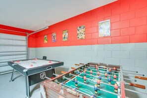 A room with a foosball table and a pool table, both with visible NHL branding.