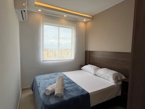 A hotel room with a bed, a window with a view, and an air conditioning unit. - TOWER 694 BUILDING, APARTMENT 503 (Cartagena de Indias)