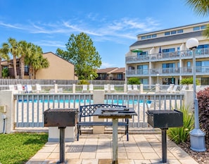 Un espace extérieur aménagé avec une terrasse, une piscine, des chaises longues et un barbecue.