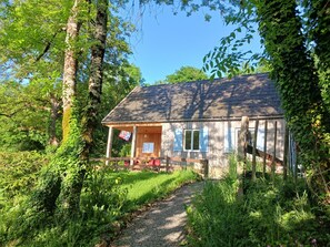 A rustic wooden house with a porch, surrounded by lush greenery and trees. - Holiday Home 'Le Sommet' with Panoramic View of the Morvan Hills and Surrounding Nature (Préporché)